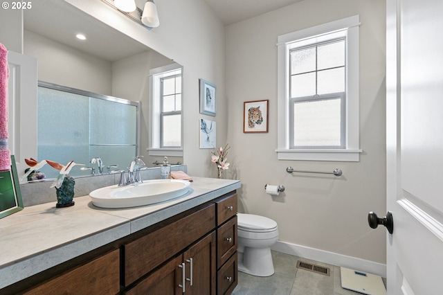bathroom featuring baseboards, plenty of natural light, toilet, and visible vents
