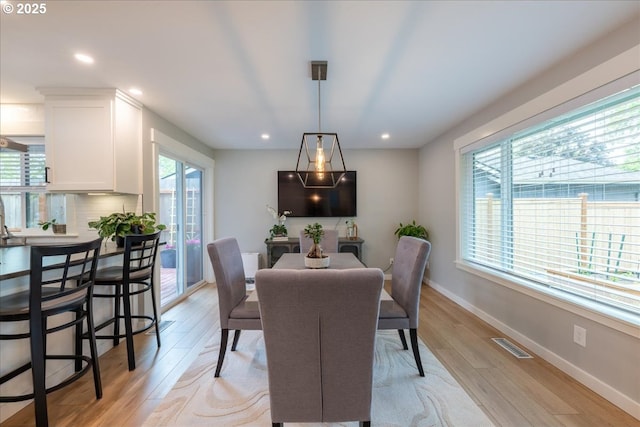 dining space with light wood-type flooring, baseboards, and recessed lighting