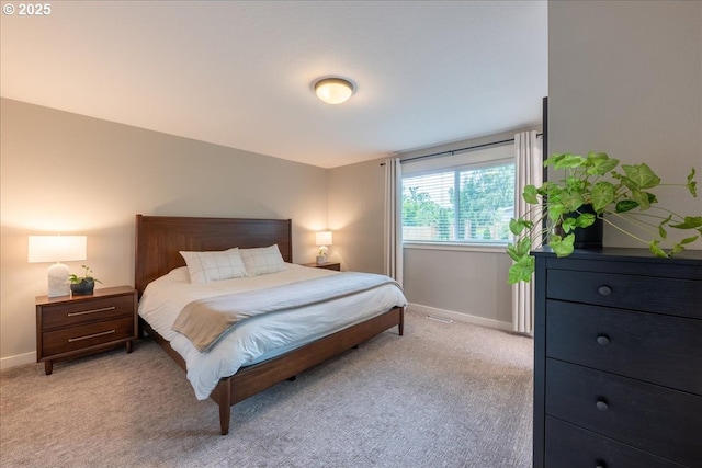 bedroom featuring light carpet and baseboards