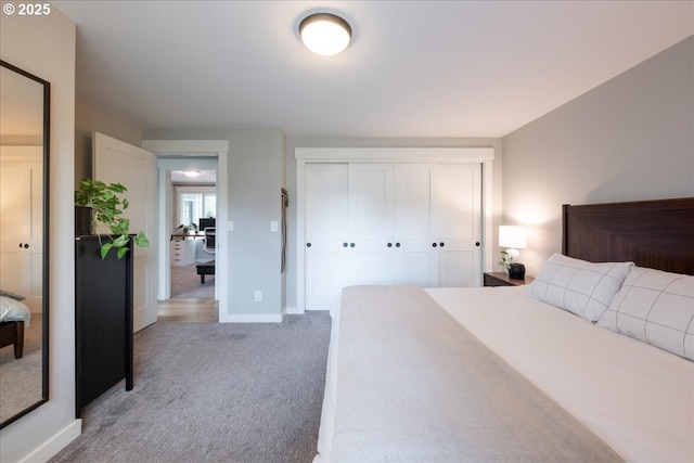 carpeted bedroom with baseboards and a closet
