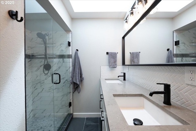 full bathroom featuring a stall shower, baseboards, tasteful backsplash, and double vanity