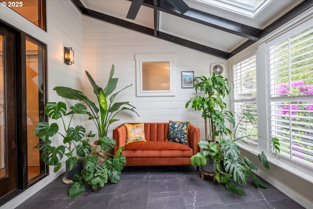sunroom / solarium featuring wood walls and a skylight