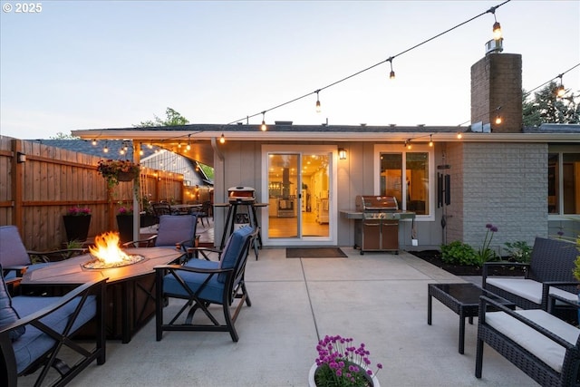 view of patio / terrace with a fire pit, fence, and grilling area