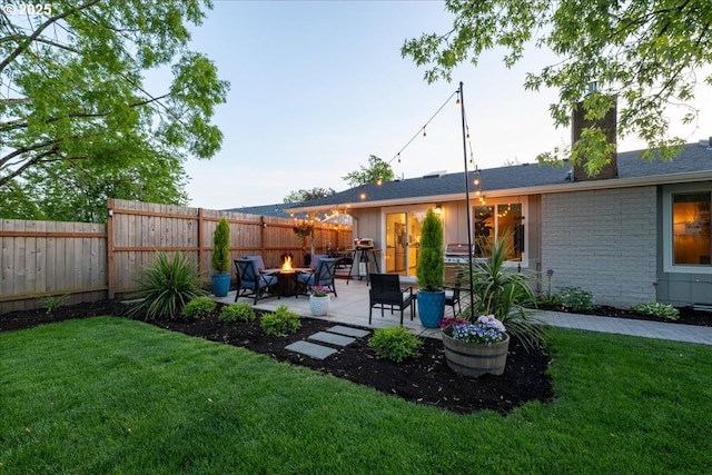 rear view of house with a patio area, a fire pit, a chimney, and stone siding