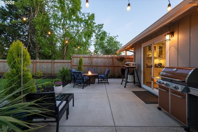view of patio / terrace with a fire pit, a fenced backyard, and area for grilling
