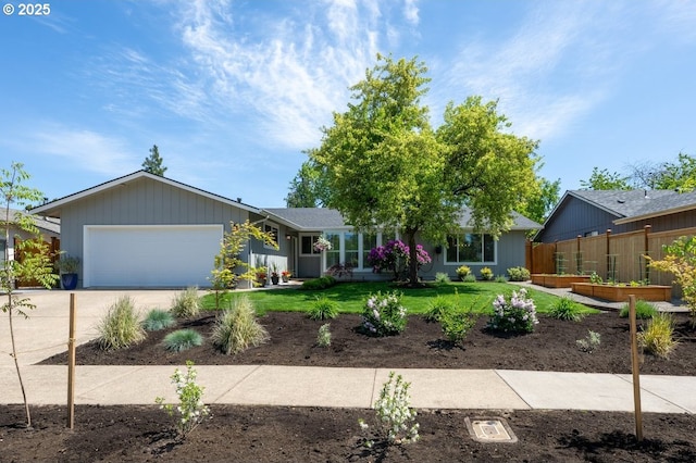 view of front of house featuring a vegetable garden, an attached garage, and driveway