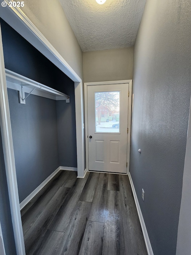 doorway to outside featuring dark hardwood / wood-style floors and a textured ceiling