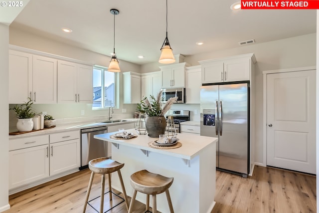 11325 NW Main St, North Plains, OR 97133 - kitchen with stainless steel appliances, a sink, white cabinetry, light countertops, and light wood-type flooring