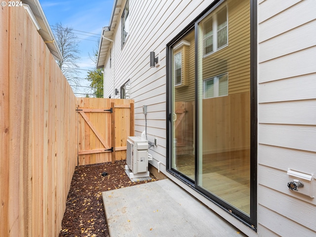 view of side of property with a patio area and ac unit