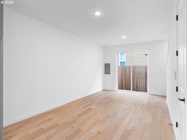 unfurnished room with electric panel and light wood-type flooring