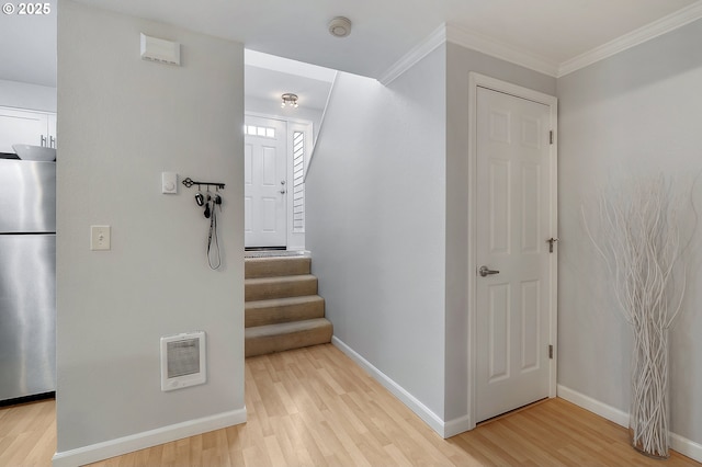 hall featuring visible vents, ornamental molding, light wood finished floors, baseboards, and stairs