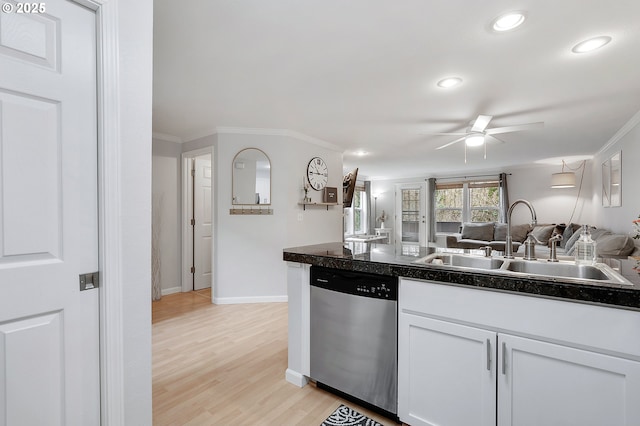 kitchen featuring dark countertops, ornamental molding, dishwasher, and a sink