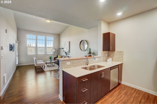 16417 NW Chadwick Way Unit 302, Portland, OR 97229 - kitchen featuring stainless steel dishwasher, light countertops, tasteful backsplash, light wood-type flooring, and a peninsula