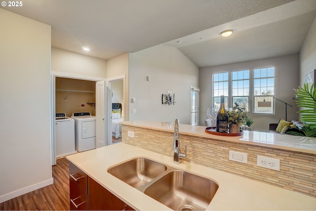 16417 NW Chadwick Way Unit 302, Portland, OR 97229 - kitchen featuring washer and clothes dryer, wood finished floors, light countertops, and lofted ceiling