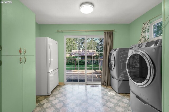 13307 SE Raymond St, Portland, OR 97236 - washroom featuring separate washer and dryer, plenty of natural light, cabinet space, and light flooring