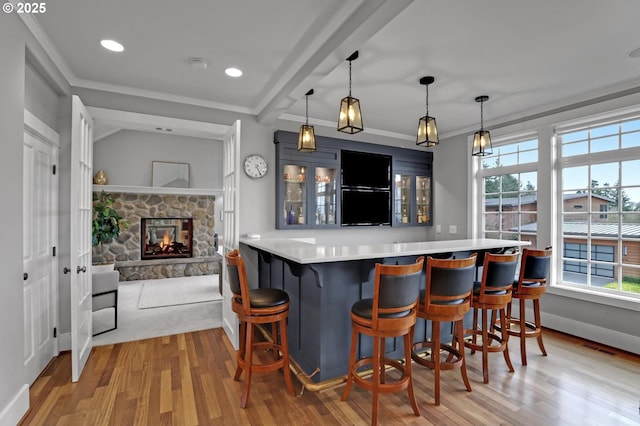 bar featuring visible vents, a fireplace, crown molding, and wood finished floors