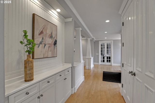 hallway with baseboards, ornate columns, light wood-style flooring, recessed lighting, and crown molding