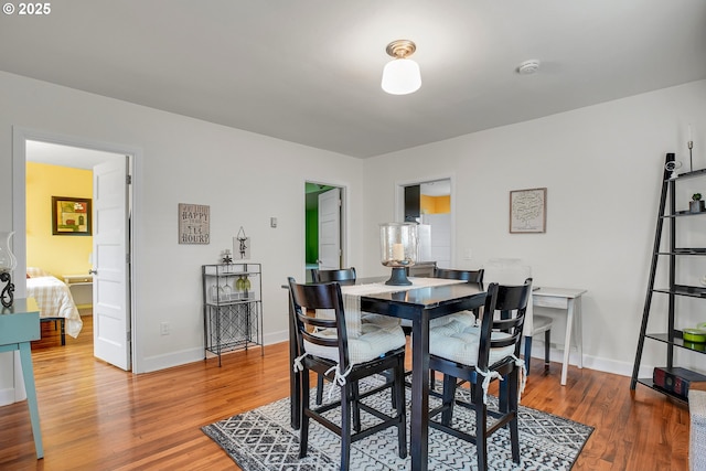 dining space featuring baseboards and wood finished floors