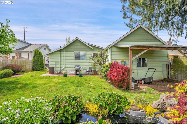 back of property featuring a lawn, fence, and cooling unit