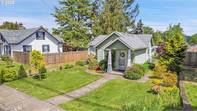 bungalow-style house featuring fence and a front yard