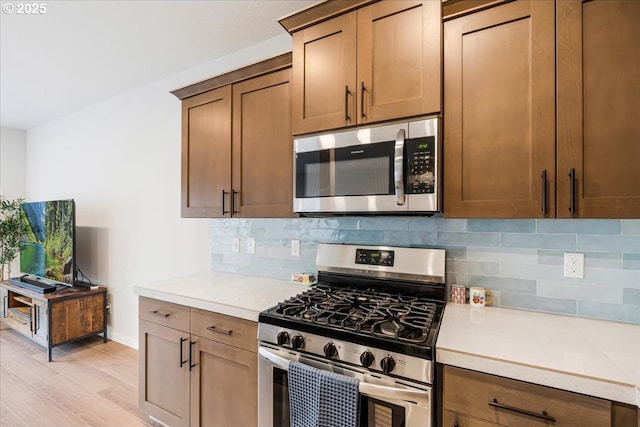 2856 S Nectarine St, Cornelius, OR 97113 - kitchen with stainless steel appliances, light wood-style flooring, decorative backsplash, and light countertops