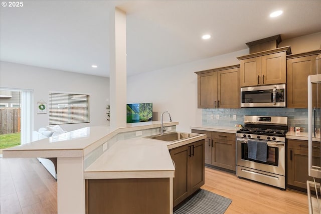 2856 S Nectarine St, Cornelius, OR 97113 - kitchen with stainless steel appliances, a sink, decorative backsplash, light wood-type flooring, and light countertops
