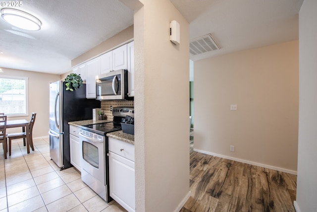 5354 Cody Ave, Eugene, OR 97402 - kitchen with appliances with stainless steel finishes, white cabinetry, backsplash, light stone countertops, and light wood-style flooring
