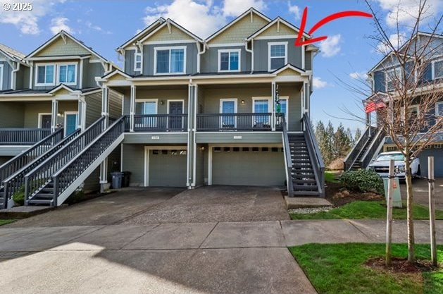 view of front of property with an attached garage, stairs, a porch, and concrete driveway