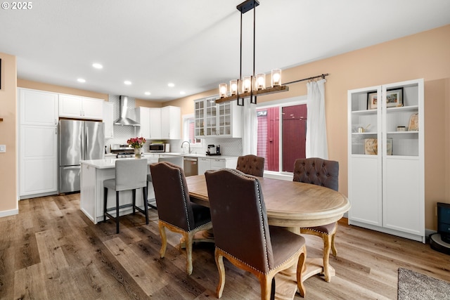 dining space featuring light wood-type flooring, a chandelier, and recessed lighting