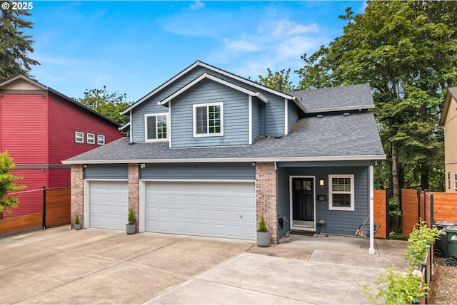 traditional-style home with roof with shingles, driveway, fence, and a garage