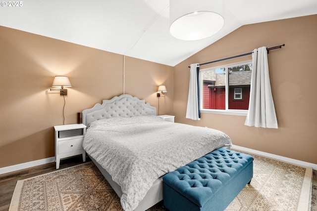 bedroom featuring baseboards, lofted ceiling, and wood finished floors