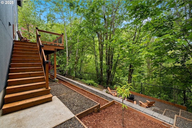 view of yard with a garden, stairway, fence, and a deck