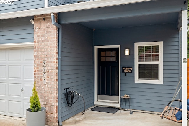 property entrance with a garage and brick siding