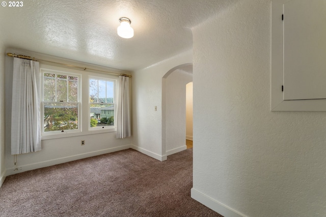 3148 Willamette St, Eugene, OR 97405 - carpeted empty room with arched walkways, a textured ceiling, a textured wall, and baseboards