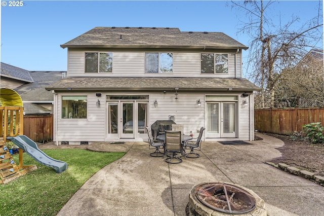 back of house with french doors, an outdoor fire pit, a playground, and fence private yard