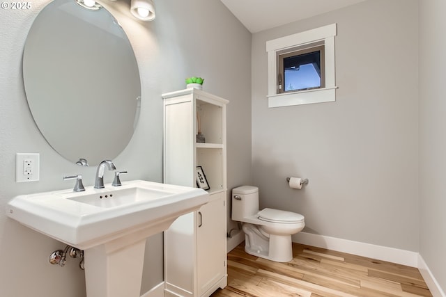 bathroom with wood-type flooring, toilet, and sink