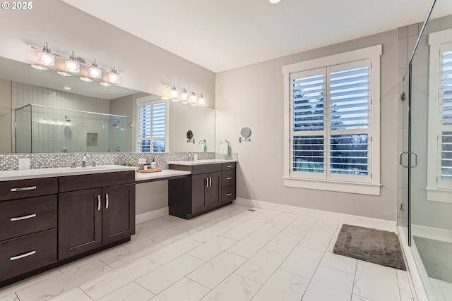 bathroom featuring backsplash, vanity, and a shower with shower door