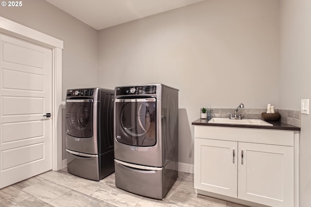 laundry room with cabinets, washing machine and dryer, and sink