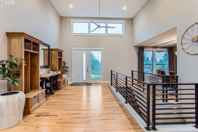 entryway with a high ceiling, light wood-type flooring, and ceiling fan