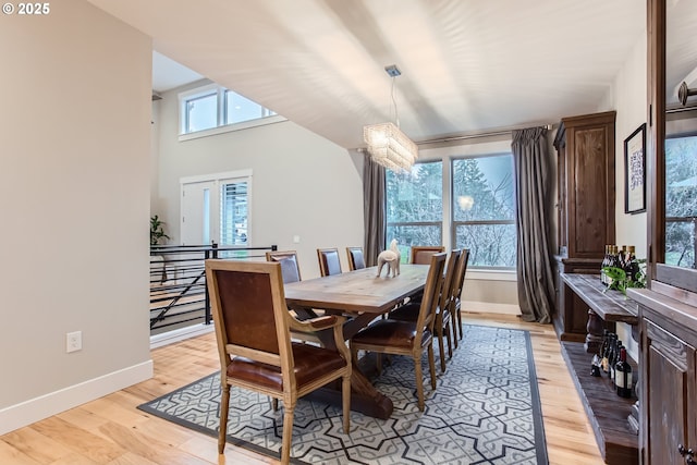 dining space with light wood-type flooring and an inviting chandelier