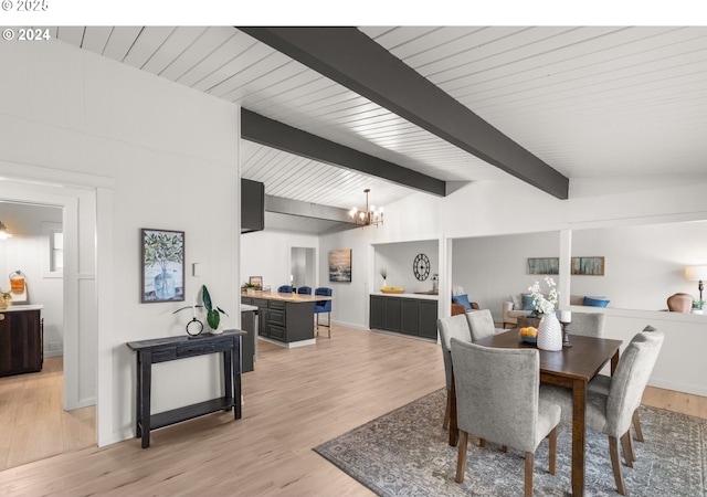 dining area featuring vaulted ceiling with beams, a notable chandelier, and light hardwood / wood-style floors