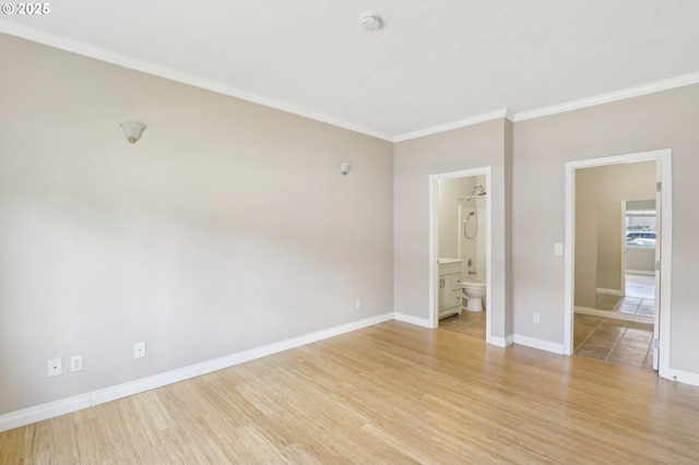 unfurnished bedroom with ornamental molding, light wood-type flooring, ensuite bath, and baseboards