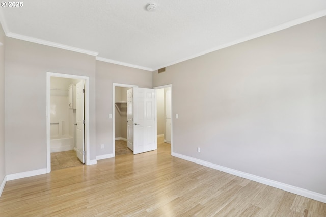 unfurnished bedroom featuring light wood-type flooring, baseboards, and ornamental molding