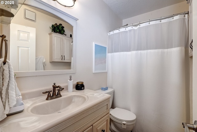 bathroom featuring vanity, toilet, and a textured ceiling