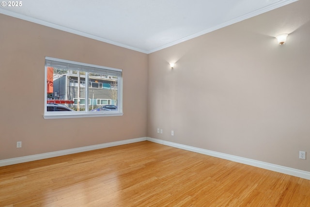 unfurnished room featuring ornamental molding and light hardwood / wood-style flooring