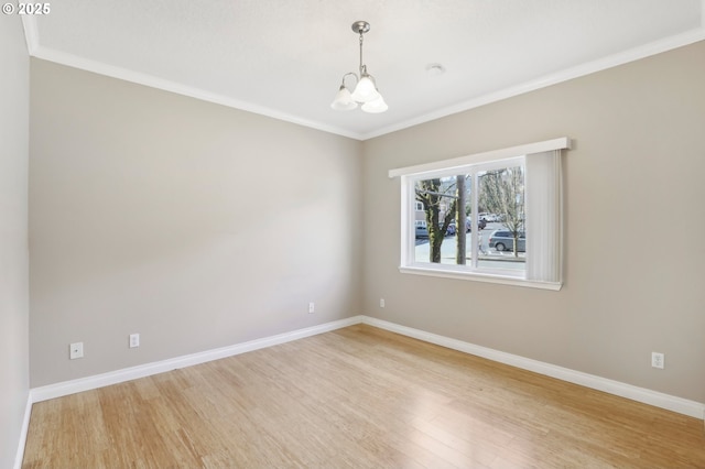 unfurnished room featuring a chandelier, crown molding, light wood-style flooring, and baseboards