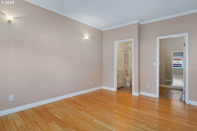 unfurnished bedroom featuring crown molding, light wood-type flooring, and ensuite bath