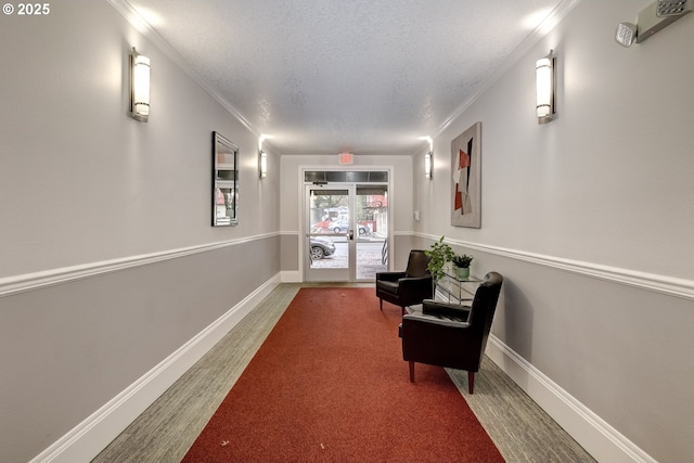 corridor featuring crown molding, wood-type flooring, and a textured ceiling