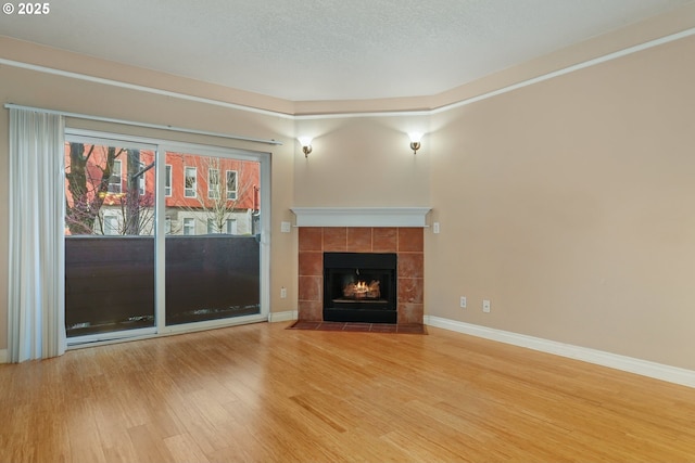 unfurnished living room featuring hardwood / wood-style flooring, a textured ceiling, and a fireplace