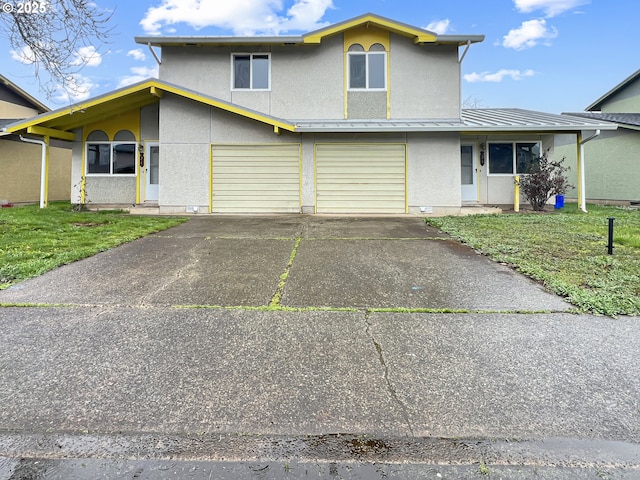 view of front of home featuring metal roof, a front yard, an attached garage, and a standing seam roof